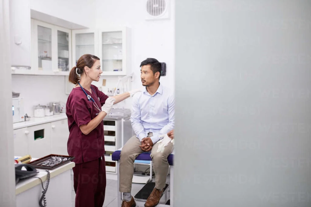 female doctor talking with male patient in clinic examination room CAIF23361